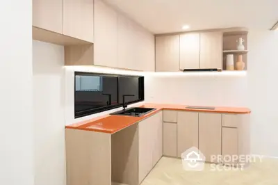 Modern kitchen with sleek cabinets and vibrant orange countertops