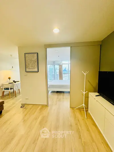 Modern open-plan living room with wooden flooring and city view