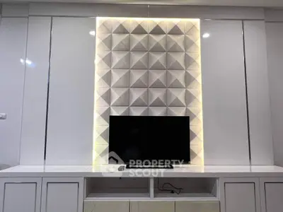 Modern living room with stylish TV setup and geometric wall design