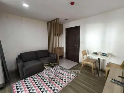 Modern living room with stylish furniture and geometric rug in a cozy apartment setting.