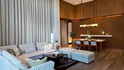 Luxurious living room with high ceilings, elegant decor, and spacious seating area in modern apartment.