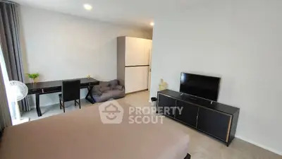 Modern bedroom with sleek furniture and workspace, ideal for urban living.