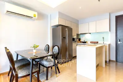 Modern kitchen with dining area featuring sleek appliances and elegant decor.