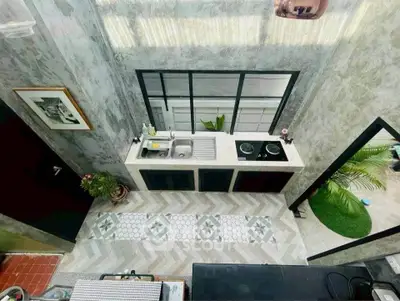 Modern kitchen with open layout and stylish design, featuring a sleek countertop and large window view.