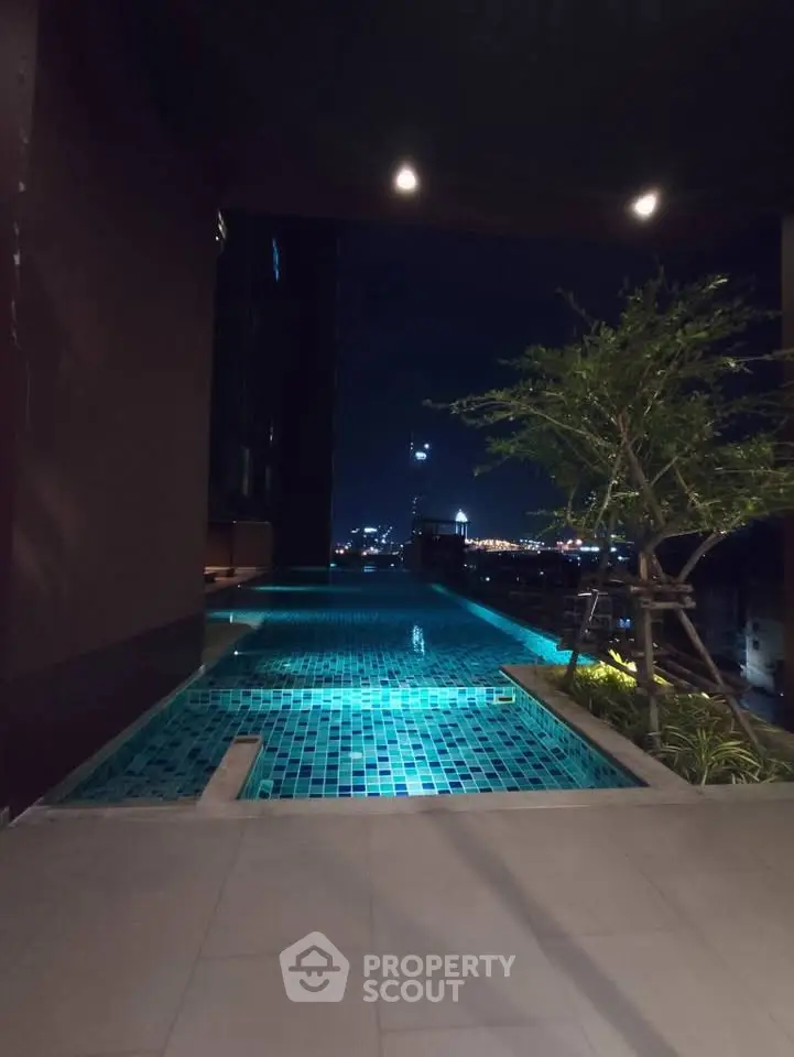 Luxurious rooftop pool with stunning city night view, perfect for relaxation and entertainment.