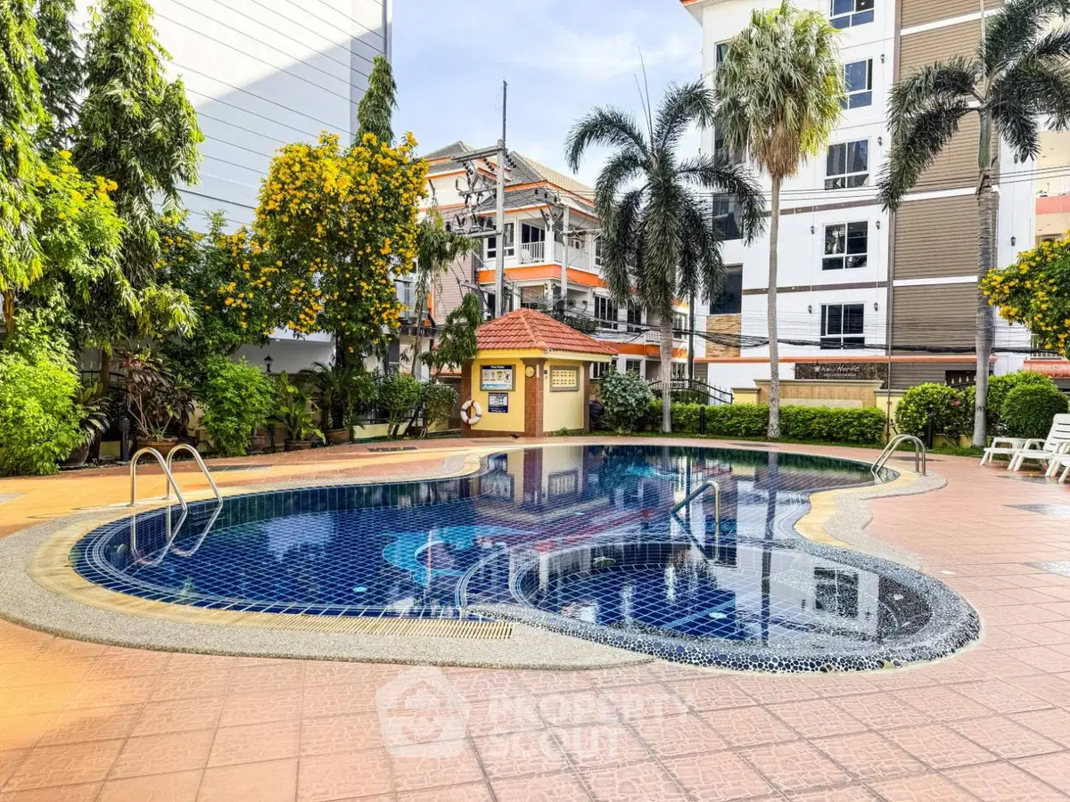 Luxurious residential pool area with lush greenery and modern building backdrop.