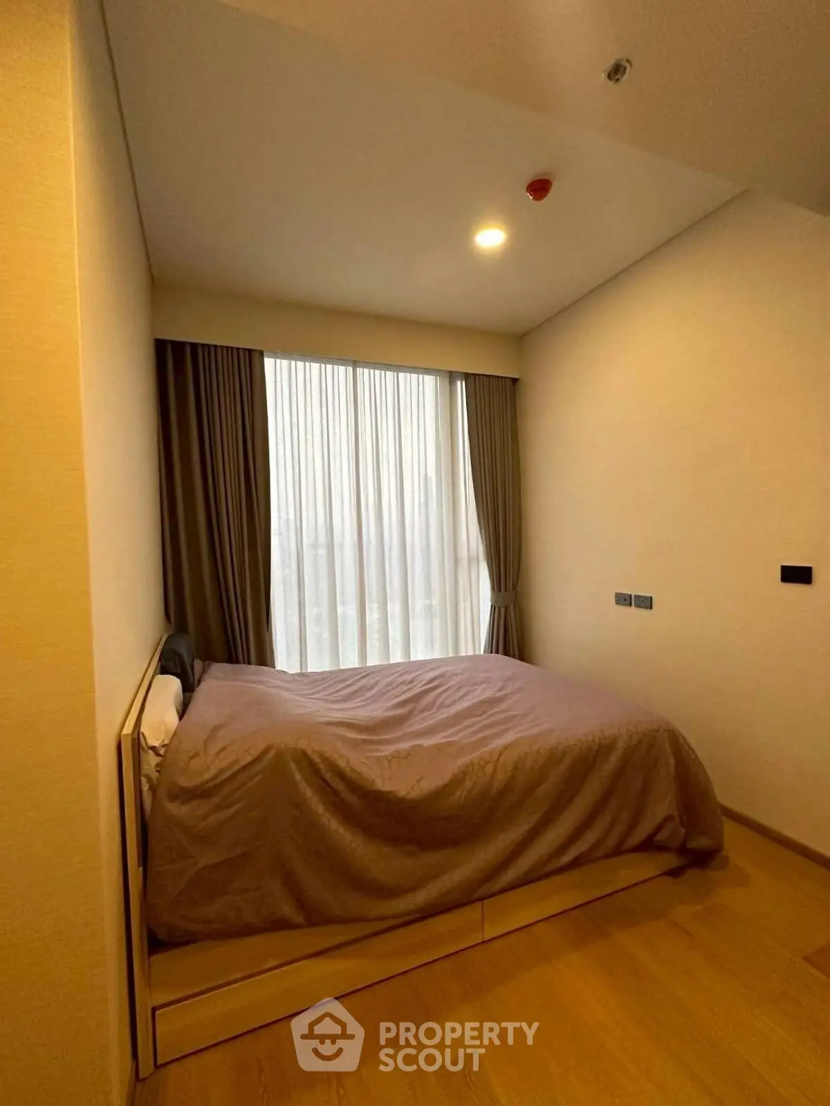 Cozy bedroom with large window and elegant curtains in modern apartment