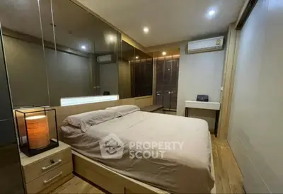 Modern bedroom with mirrored walls and ambient lighting in a stylish apartment.