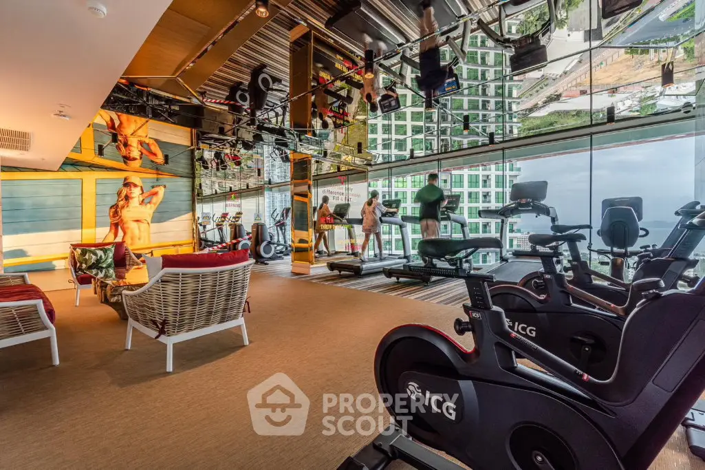 Luxurious gym with panoramic city views and modern fitness equipment in high-rise building.