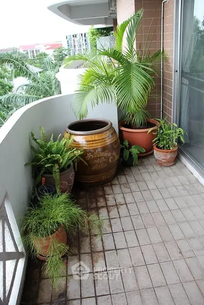 Charming balcony with lush potted plants and tiled flooring, perfect for relaxation.