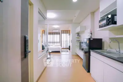 Modern open-layout apartment with sleek kitchen and cozy living area, perfect for urban living.