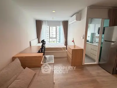 Modern studio apartment with open layout, featuring a cozy living area and a compact kitchen.