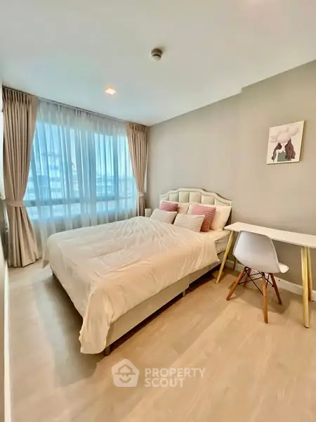 Cozy bedroom with modern decor and natural light in a stylish apartment.