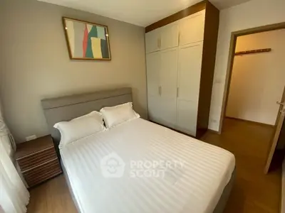 Cozy bedroom with modern decor and ample closet space in a stylish apartment.