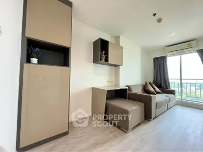 Modern living room with sleek furniture and large window offering a scenic view.
