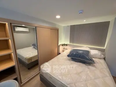 Modern bedroom with mirrored wardrobe and cozy lighting in a stylish apartment.