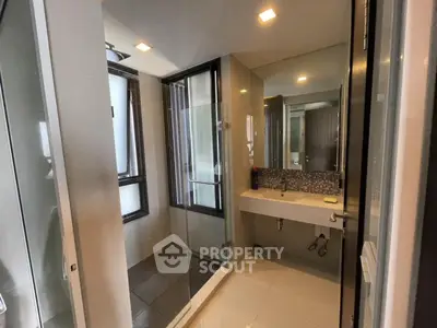 Modern bathroom with glass shower and sleek vanity in contemporary apartment