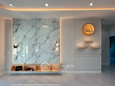 Luxurious modern living room with marble accent wall and ambient lighting