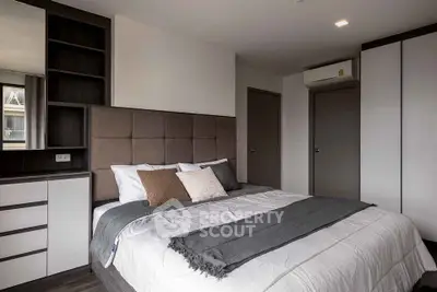 Modern bedroom with stylish decor and ample storage in a contemporary apartment.