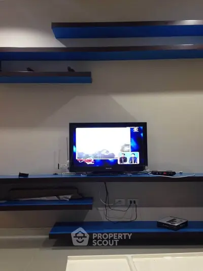 Modern living room with sleek blue shelves and mounted TV, perfect for entertainment.