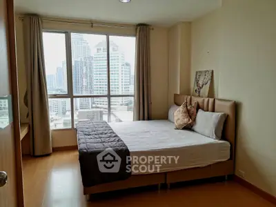 Modern bedroom with city view, featuring a cozy bed and large windows in a high-rise apartment.