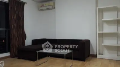 Cozy living room with dark sofa and modern glass coffee table