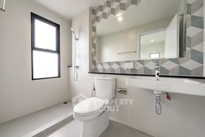 Modern bathroom with geometric tile accents and large mirror