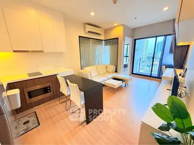 Modern open-plan living room with city view, featuring sleek kitchen and cozy seating area.