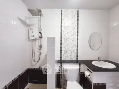 Modern bathroom with sleek shower and stylish black and white tile design.
