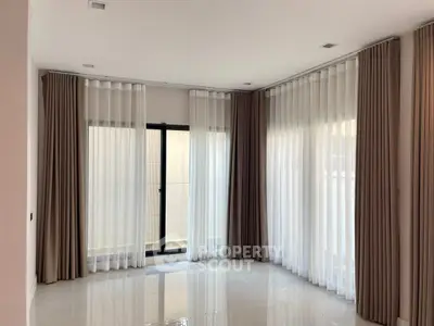 Spacious corner unit with elegant floor-to-ceiling curtains and natural light.