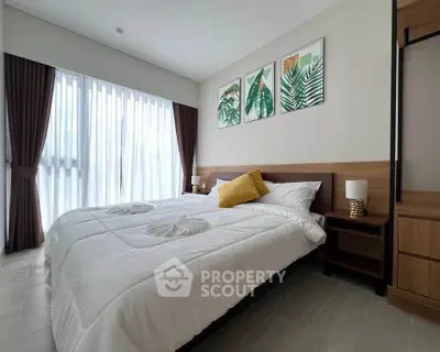 Modern bedroom with large window, stylish decor, and cozy bedding