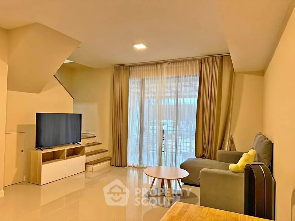 Spacious living room with modern decor and large windows for natural light.