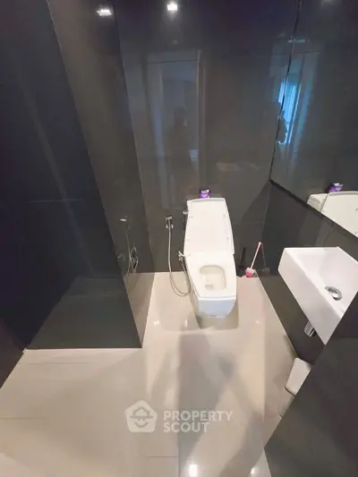 Modern bathroom with sleek black tiles and contemporary fixtures.