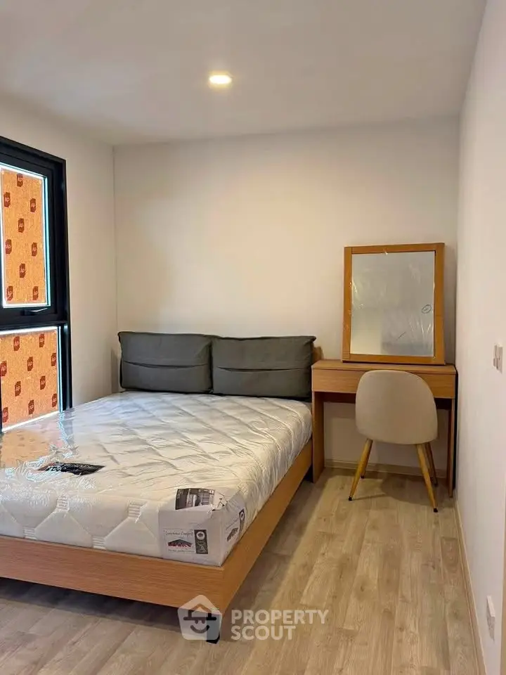Cozy bedroom with modern furnishings and natural light, perfect for relaxation and comfort.