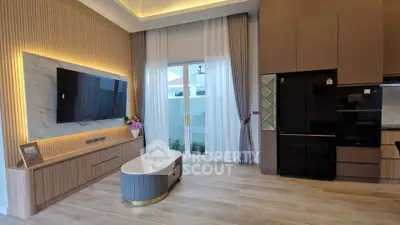 Modern living room with stylish decor and large TV, featuring elegant lighting and sleek furniture.