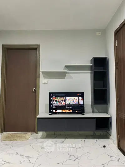 Modern living room with wall-mounted TV and sleek storage units.