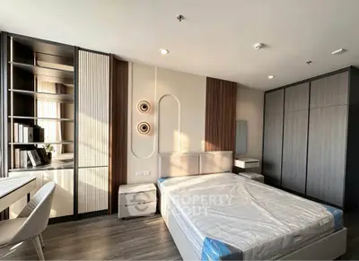 Modern bedroom with stylish decor and ample storage space, featuring a sleek design and natural light.