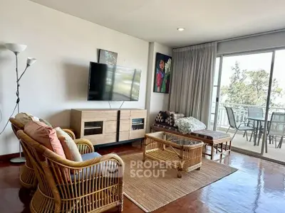 Spacious living room with modern decor and balcony access, featuring stylish furniture and natural light.