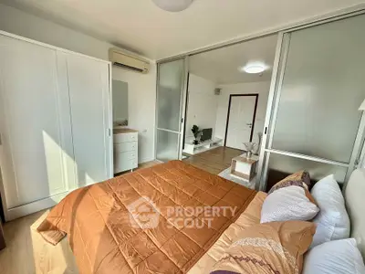 Modern bedroom with sliding glass doors and cozy decor in a stylish apartment.