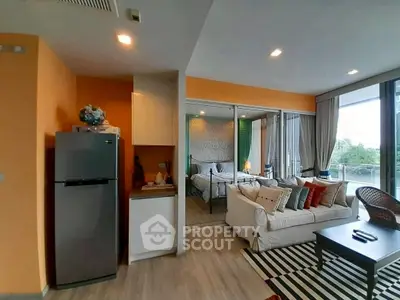 Modern open-plan living room with cozy seating and bedroom view