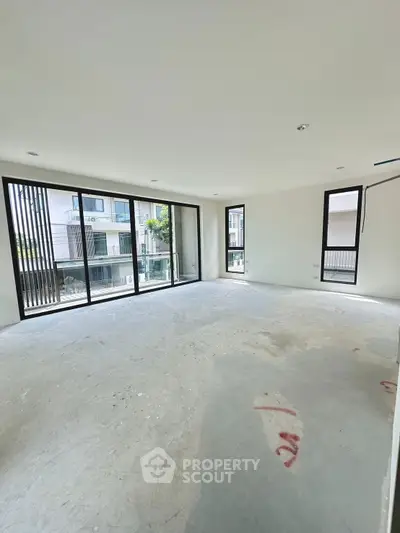 Spacious unfurnished living room with large windows and balcony view