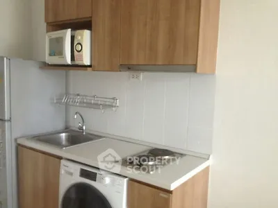 Compact kitchen with modern appliances and wooden cabinetry