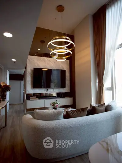 Luxurious modern living room with elegant lighting and large TV, perfect for relaxation and entertainment.