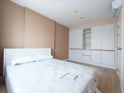Spacious bedroom with modern white wardrobe and comfortable bed in a stylish apartment.