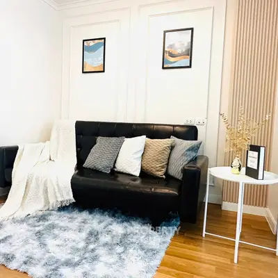 Stylish living room with modern sofa, cozy rug, and elegant decor accents.