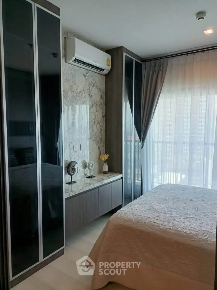 Modern bedroom with large windows and stylish decor in a high-rise apartment.