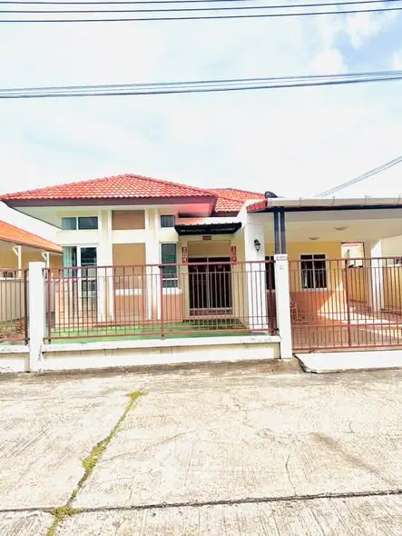 Charming single-story house with red-tiled roof and gated entrance, perfect for family living.
