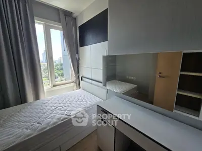 Modern bedroom with city view, sleek furniture, and ample natural light.