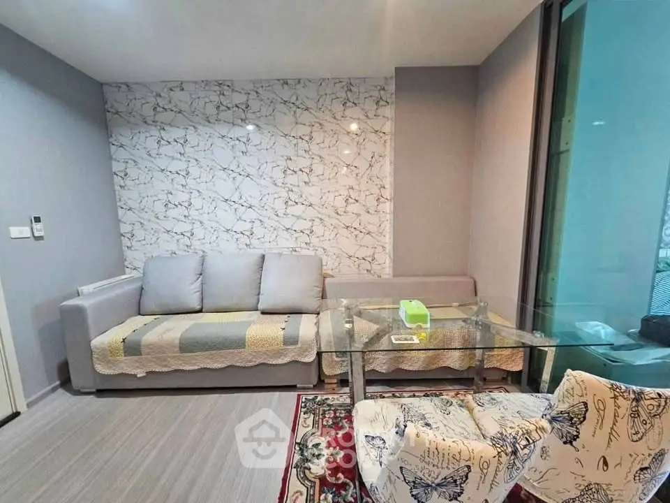 Modern living room with stylish decor and glass table in a cozy apartment.
