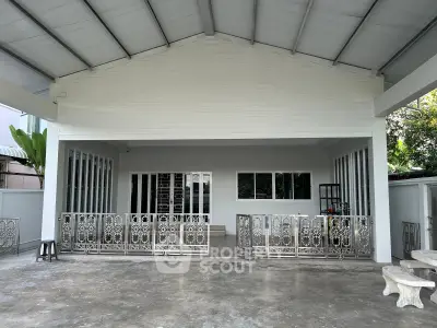 Spacious covered outdoor area with decorative metal fencing and concrete flooring